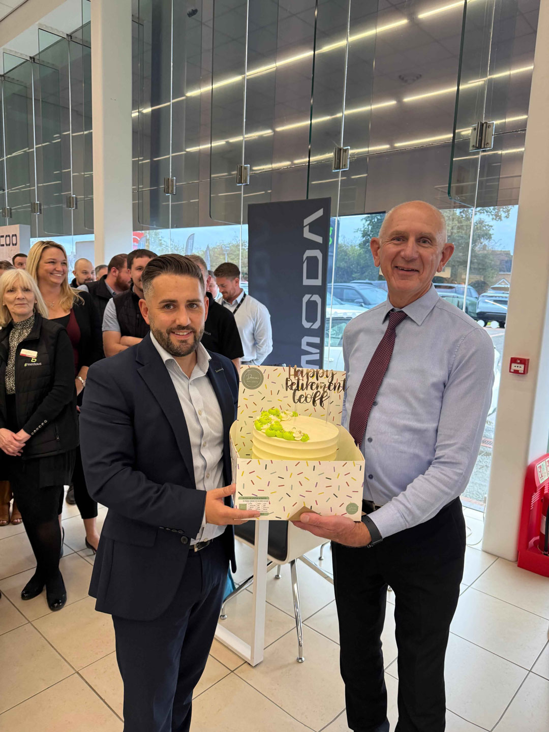 Danny Minshall presenting cake to Geoff Lowe